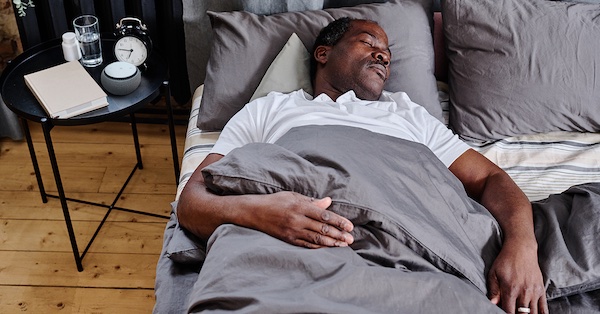 A man sleeping in his bed.